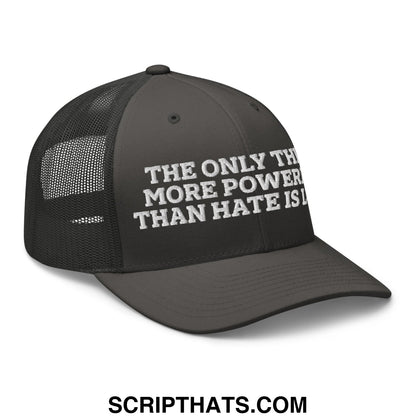 Black mesh trucker hat with white embroidered text the only thing more powerful than hate is love on front panels