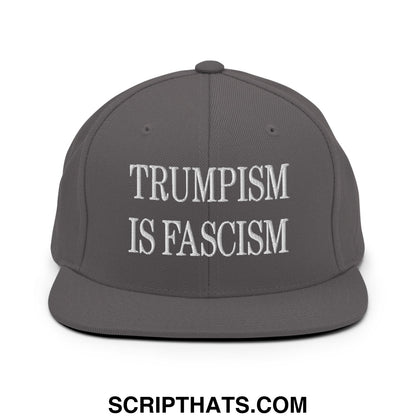 Dark gray snapback hat with white embroidered text trumpism is fascism on a flat bill brim design