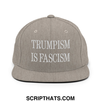 Gray snapback hat with white embroidered text reading trumpism is fascism featuring a flat bill brim design