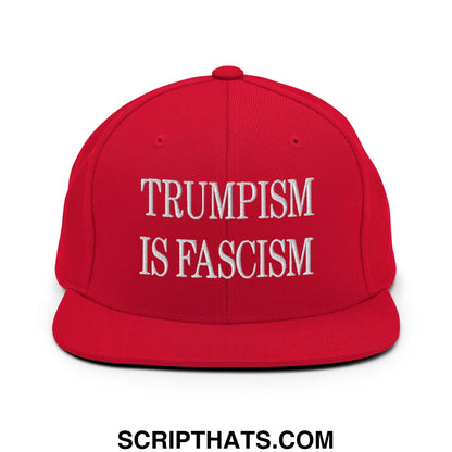 Red snapback cap with flat bill brim and white embroidered text reading trumpism is fascism in bold letters