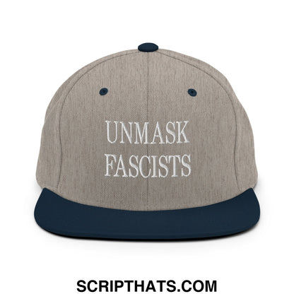A gray and navy blue snapback hat with white embroidered unmask fascists text on the front flat bill brim