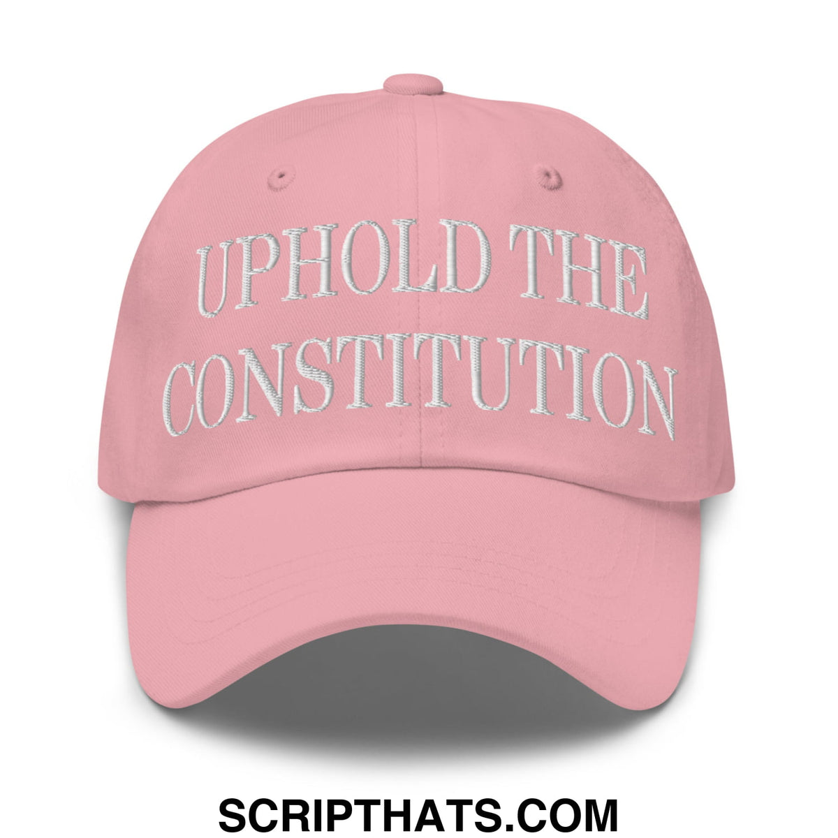 A soft pink unstructured dad hat with uphold the constitution embroidered in white thread on the front