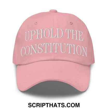 A soft pink unstructured dad hat with uphold the constitution embroidered in white thread on the front