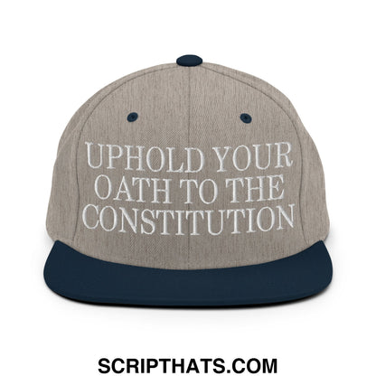 A gray and navy blue snapback hat with white embroidered uphold your oath to the constitution text on flat bill brim