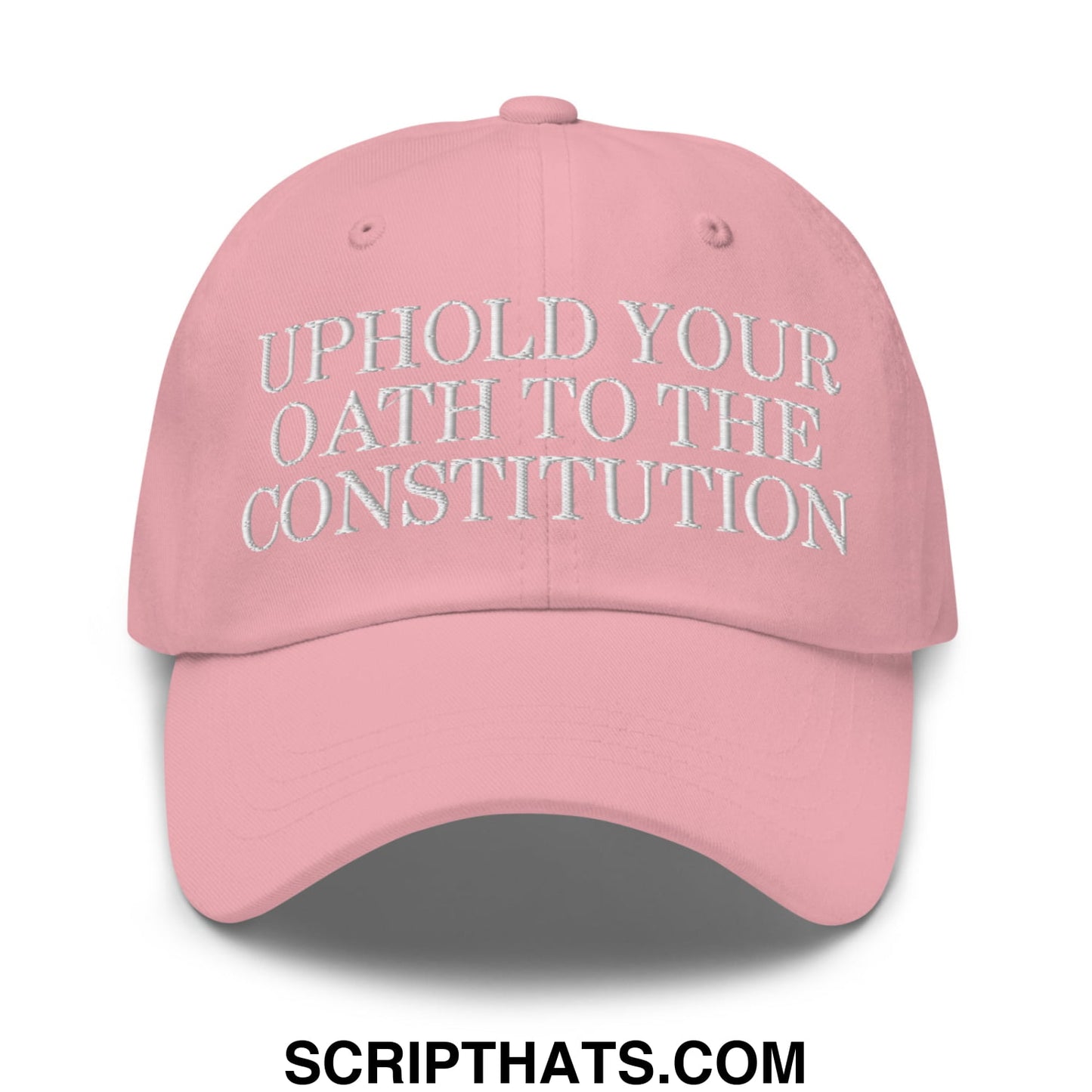 A soft pink unstructured dad hat with white embroidered text uphold your oath to the constitution