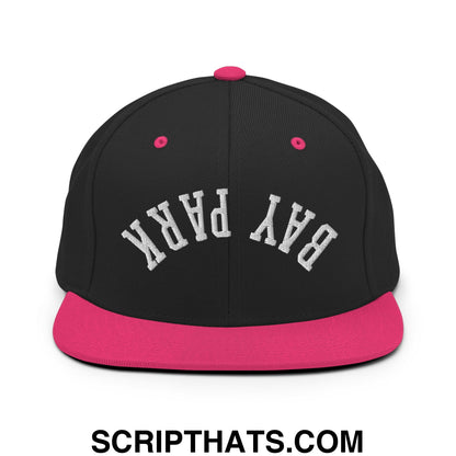 Black snapback hat with vibrant pink flat bill brim and button featuring bay park embroidered in white arched lettering