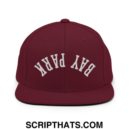 Maroon flat bill snapback hat with white embroidered bay park lettering in a classic arched design