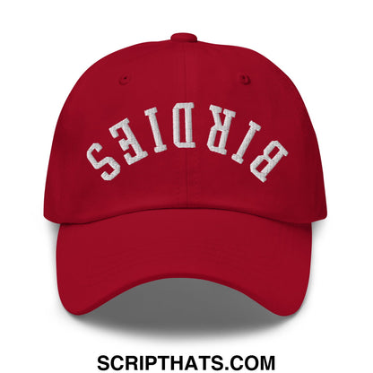 Red unstructured dad hat with white embroidered birds lettering in an arched design titled upside down birdies