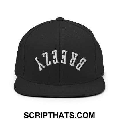 Black snapback cap with white embroidered breezy lettering in arched design and flat bill brim for casual wear