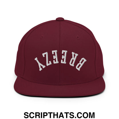 Maroon flat bill brim snapback hat with white arched breezy embroidery and adjustable closure