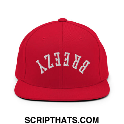 A vibrant red snapback hat with a flat bill brim and white embroidered breezy lettering in an arched design