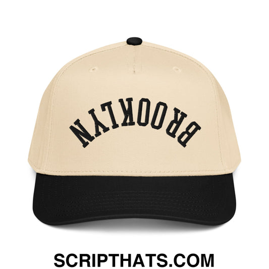 Beige and black baseball snapback hat with brooklyn embroidered in bold black arched lettering on the front