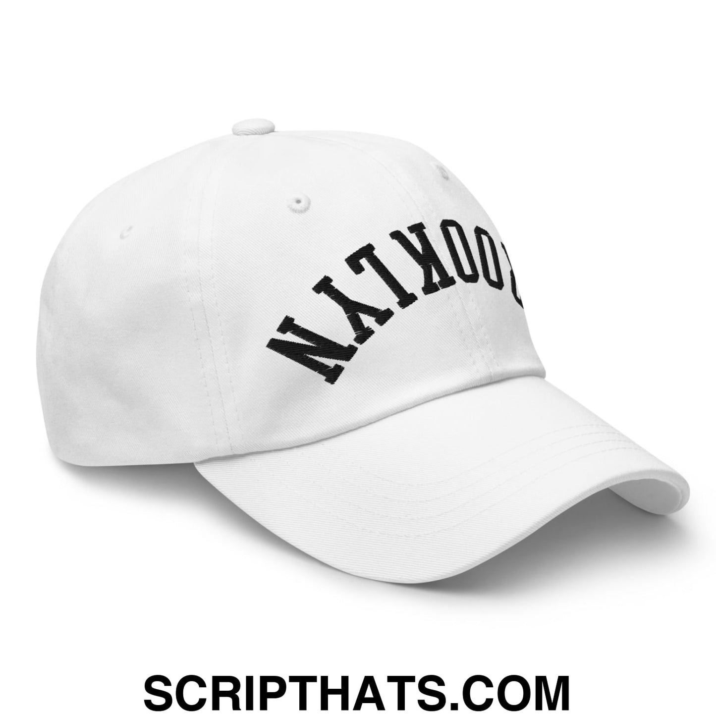 White unstructured dad hat with black arched brooklyn embroidery on front in an upside down design