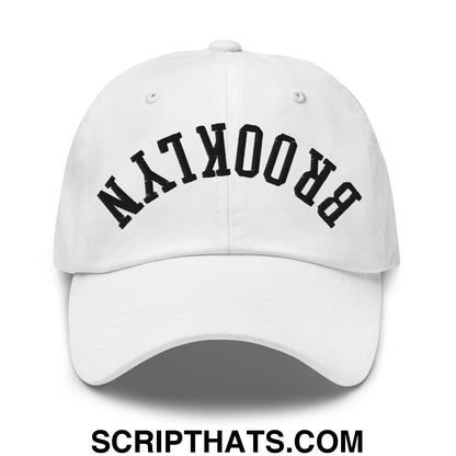 White unstructured dad hat with black arched brooklyn embroidery featuring upside down design
