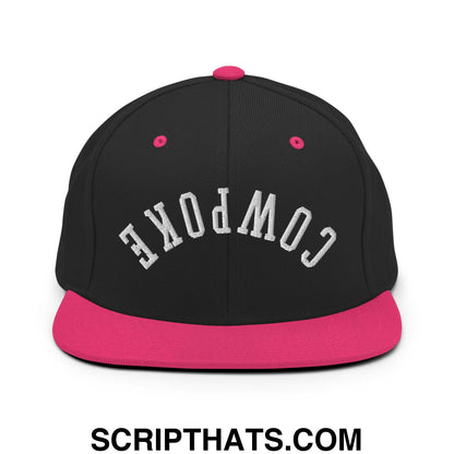 Black snapback cap with pink brim and button featuring cowpoke embroidered in white arched lettering