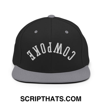 Black and gray snapback cap with white embroidered compoke lettering and flat bill brim for casual wear