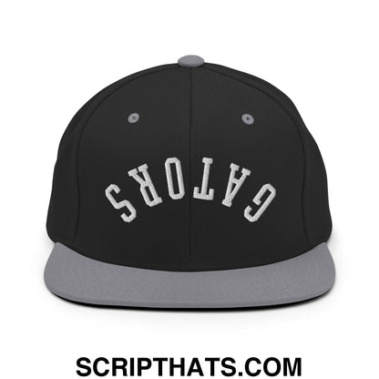 Black and gray snapback hat with white gators embroidered in arched lettering and a flat bill brim