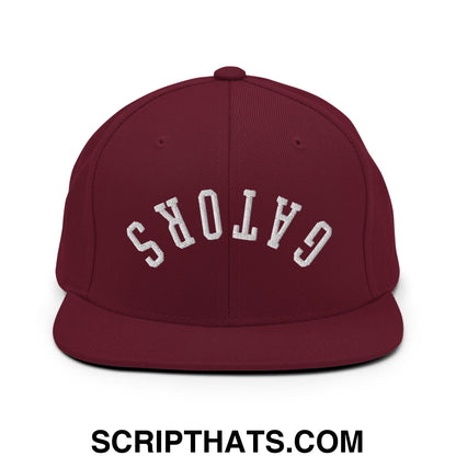 Maroon snapback cap with white embroidered gators lettering in an arched design and flat bill brim
