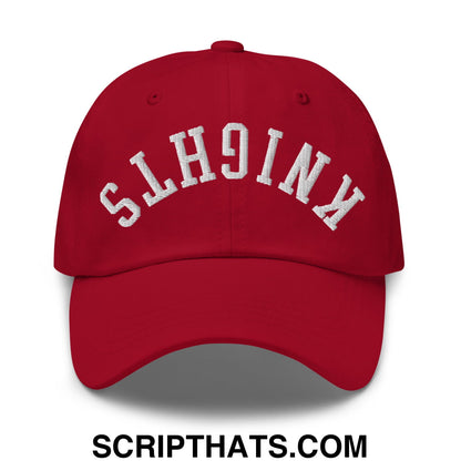 Red unstructured dad hat with white embroidered knights lettering in an arched design