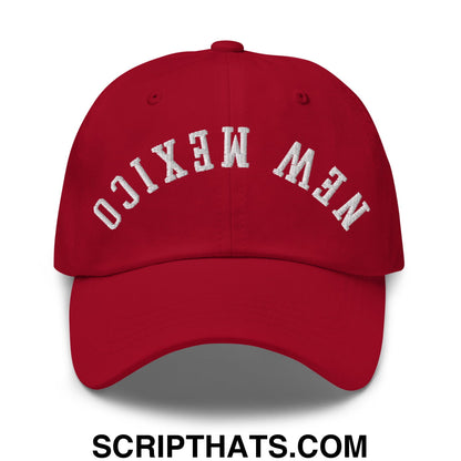 A red unstructured dad hat with new mexico embroidered in white arched lettering on the front