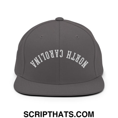 Dark gray snapback hat with white embroidered north carolina lettering and flat bill brim in an arched design