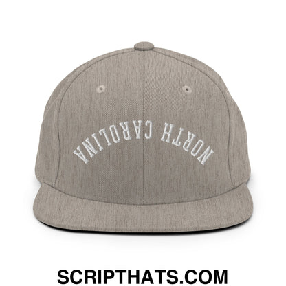 A heather gray snapback hat with north carolina embroidered in white arched lettering on the front panel