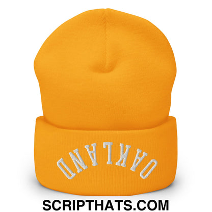 A vibrant orange knit beanie with oakland embroidered in white on the folded cuff called upside down oakland beanie