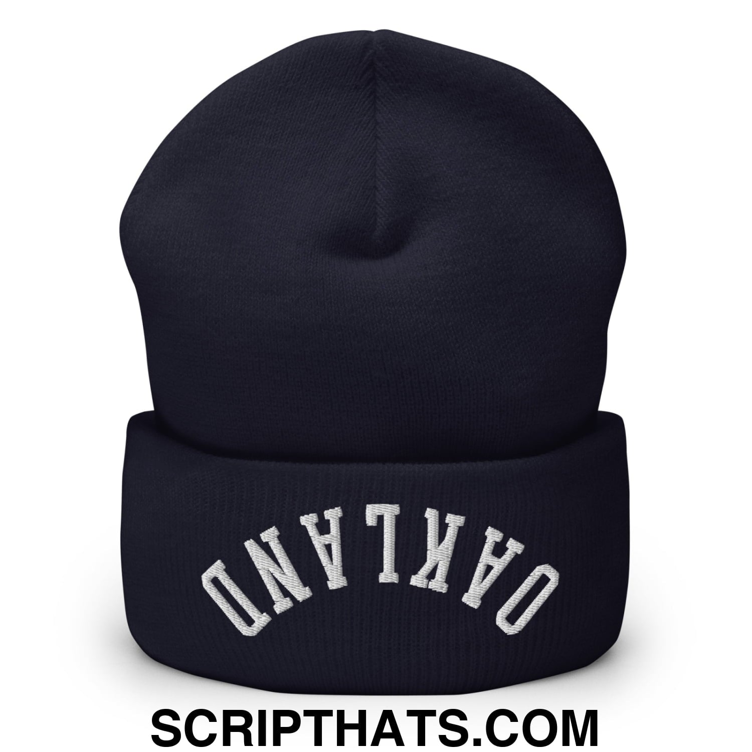 A navy blue knit cuffed beanie with upside down oakland white embroidered lettering on the folded cuff