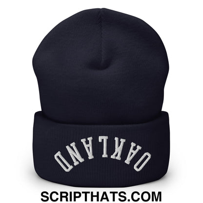 A navy blue knit cuffed beanie with upside down oakland white embroidered lettering on the folded cuff