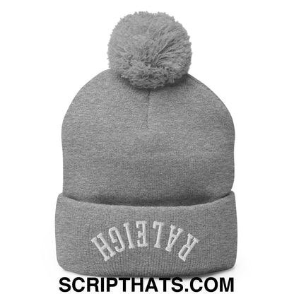 Gray knit beanie with a fuzzy pom pom and white embroidered raleigh arch on the cuff in upside down style