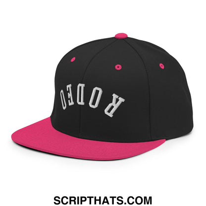 Black and pink snapback hat with white embroidered rodeo lettering and a flat bill brim design