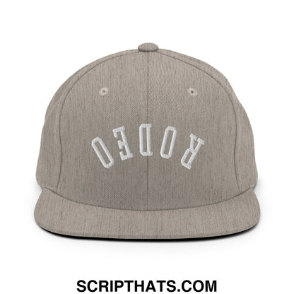Gray heather snapback hat with white embroidered rodeo lettering and flat bill brim in upside down design