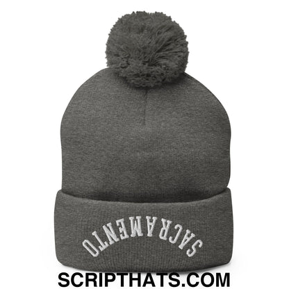 Gray knit beanie with matching fuzzy pom pom and white embroidered sacramento on folded brim in upside down style