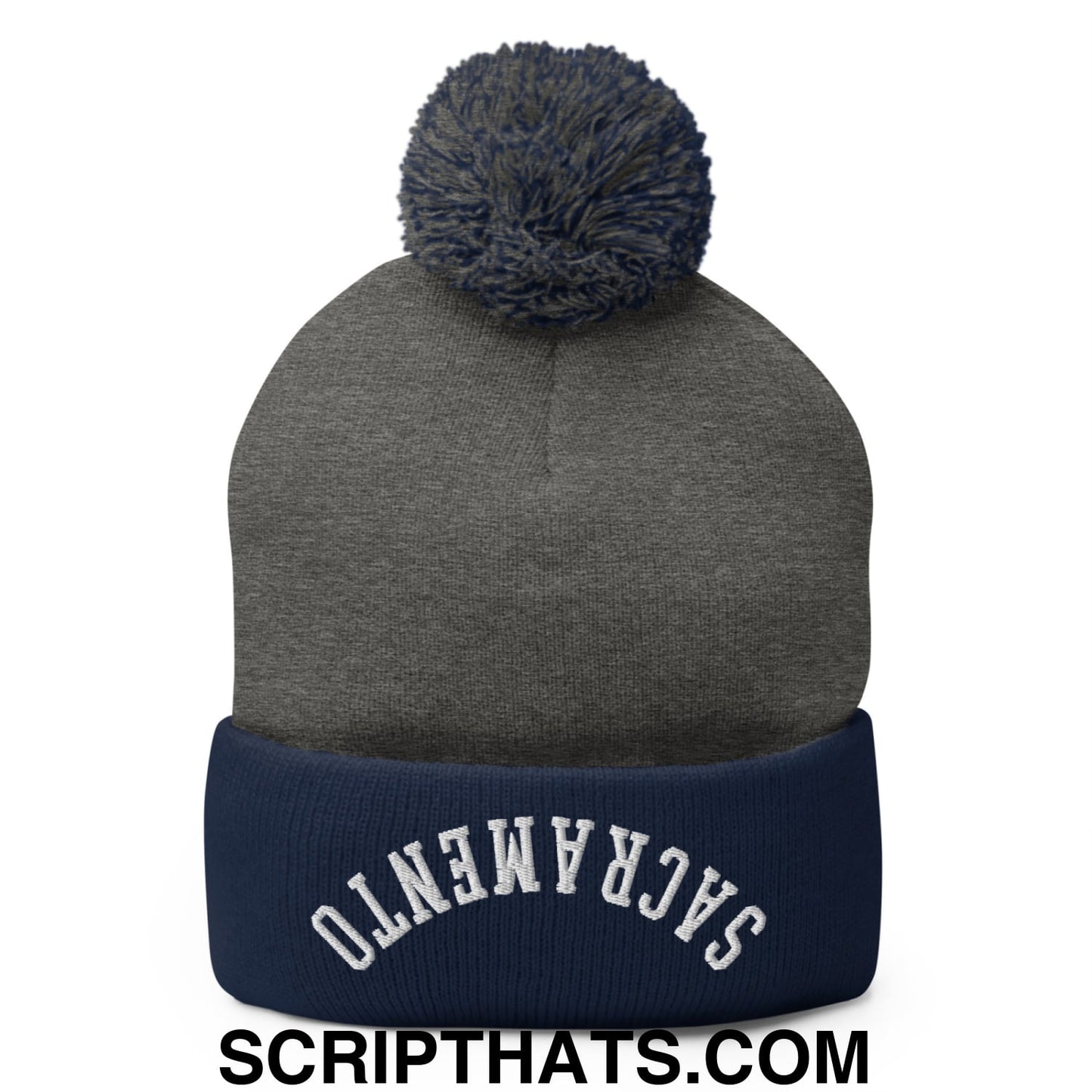 Gray knit beanie with navy blue ribbed cuff embroidered sacramento and a dark gray pom pom on top