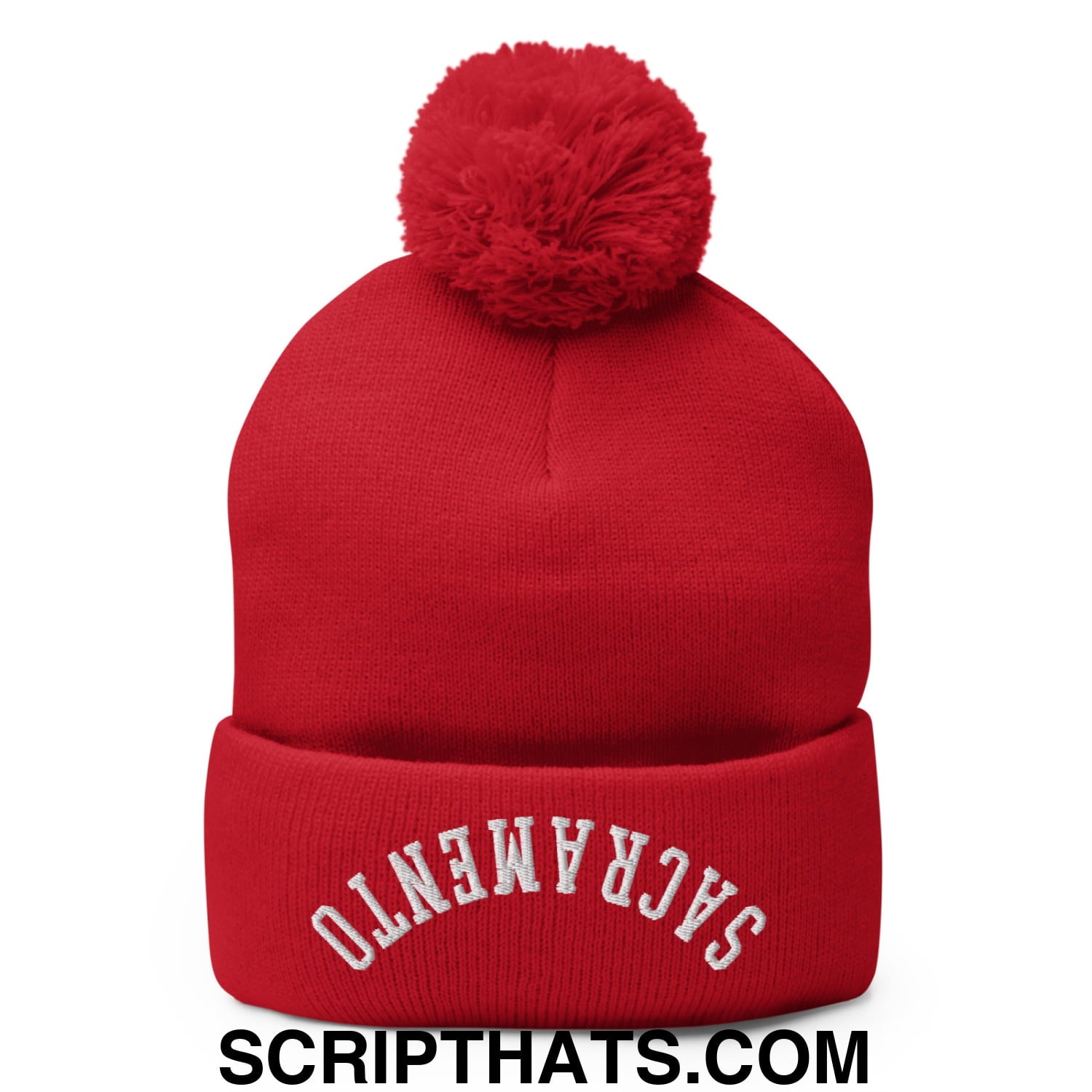 Red knit beanie with a fluffy pom pom and white embroidered sacramento on the cuff in a cozy winter design