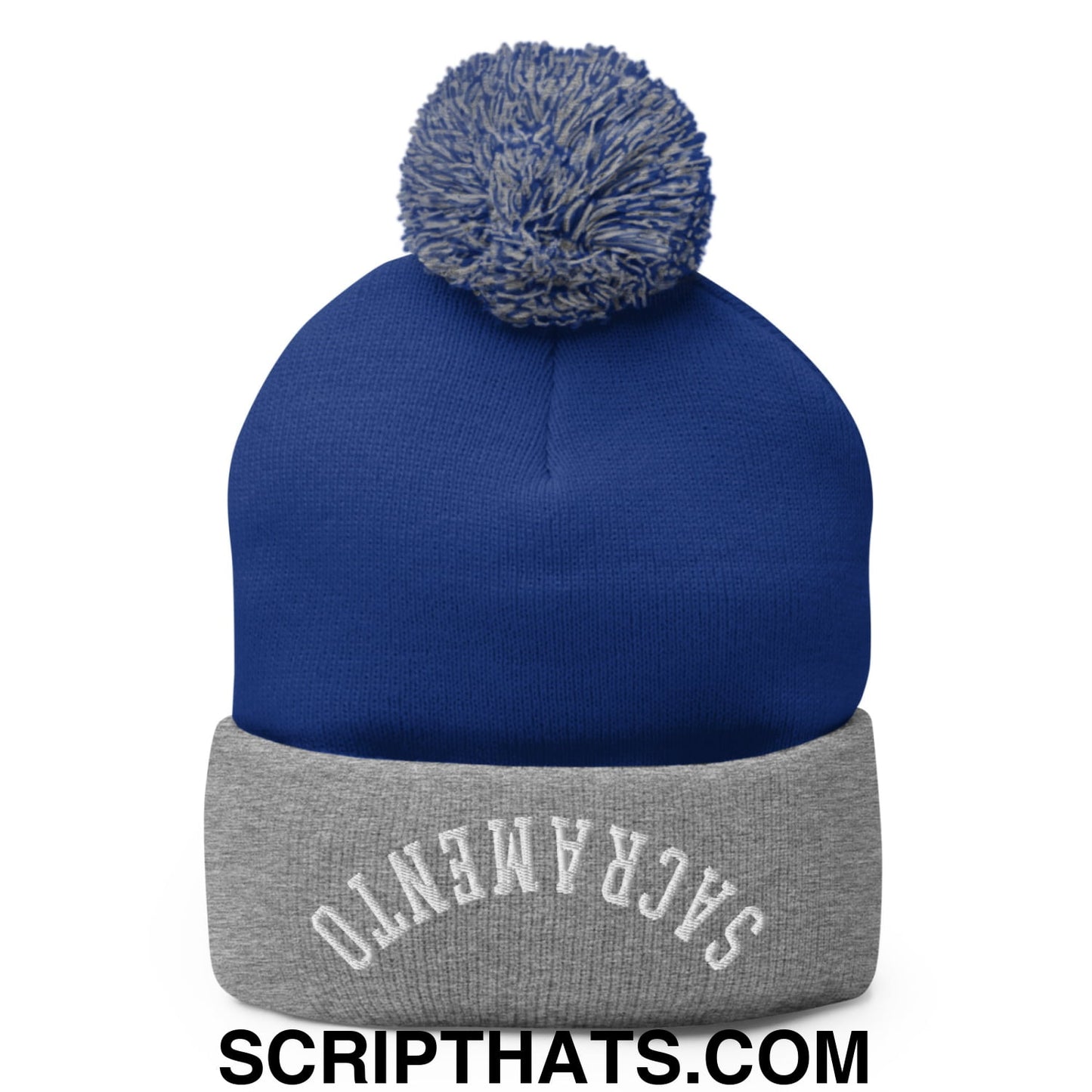 Royal blue knit beanie with gray cuff embroidered with Sacramento and topped with a fluffy gray pom pom
