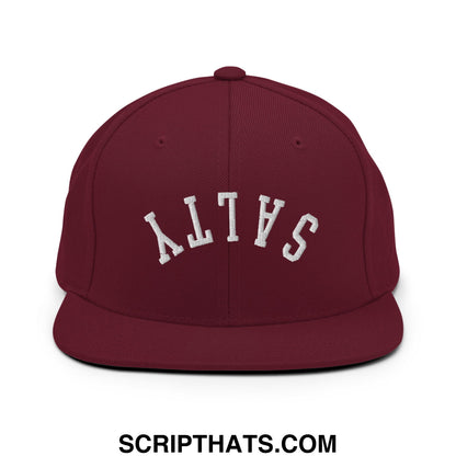 Maroon snapback cap with white embroidered salty lettering in an arched design and a flat bill brim