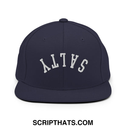 Navy blue snapback hat with white embroidered salty lettering in an arched design and flat bill brim