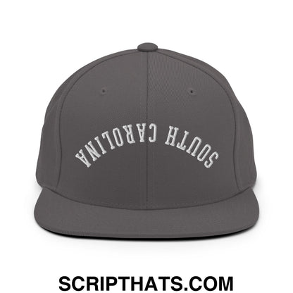 A dark gray flat bill snapback hat with white south carolina embroidery on the front panel