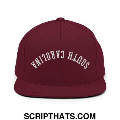 Maroon flat bill brim snapback hat with white embroidered south Carolina lettering in upside down design