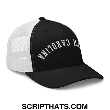 Black and white mesh trucker hat with north carolina embroidered in silver thread on front panel titled upside down south carolina