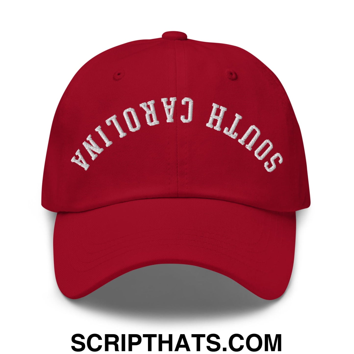 Red unstructured dad hat with white embroidered south carolina text in an arched design featuring upside down style