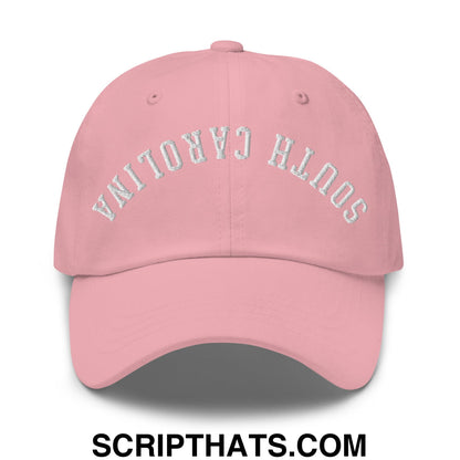 A soft pink unstructured dad hat with south carolina embroidered in silver thread across the front