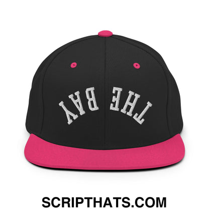 Black snapback cap with vibrant pink flat bill brim and button featuring the bay embroidered in white lettering