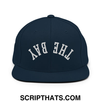 Navy blue snapback hat with white embroidered the bay lettering in classic arched design and flat bill brim