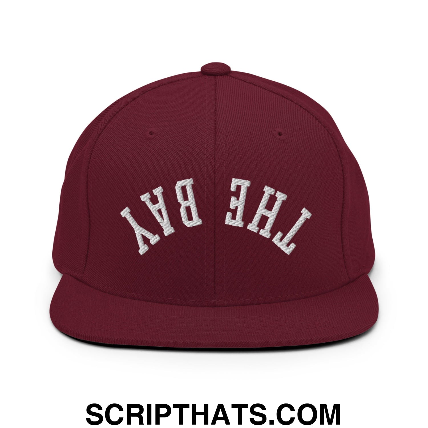 Maroon snapback cap with white embroidered the bay lettering and flat bill brim in upside down design