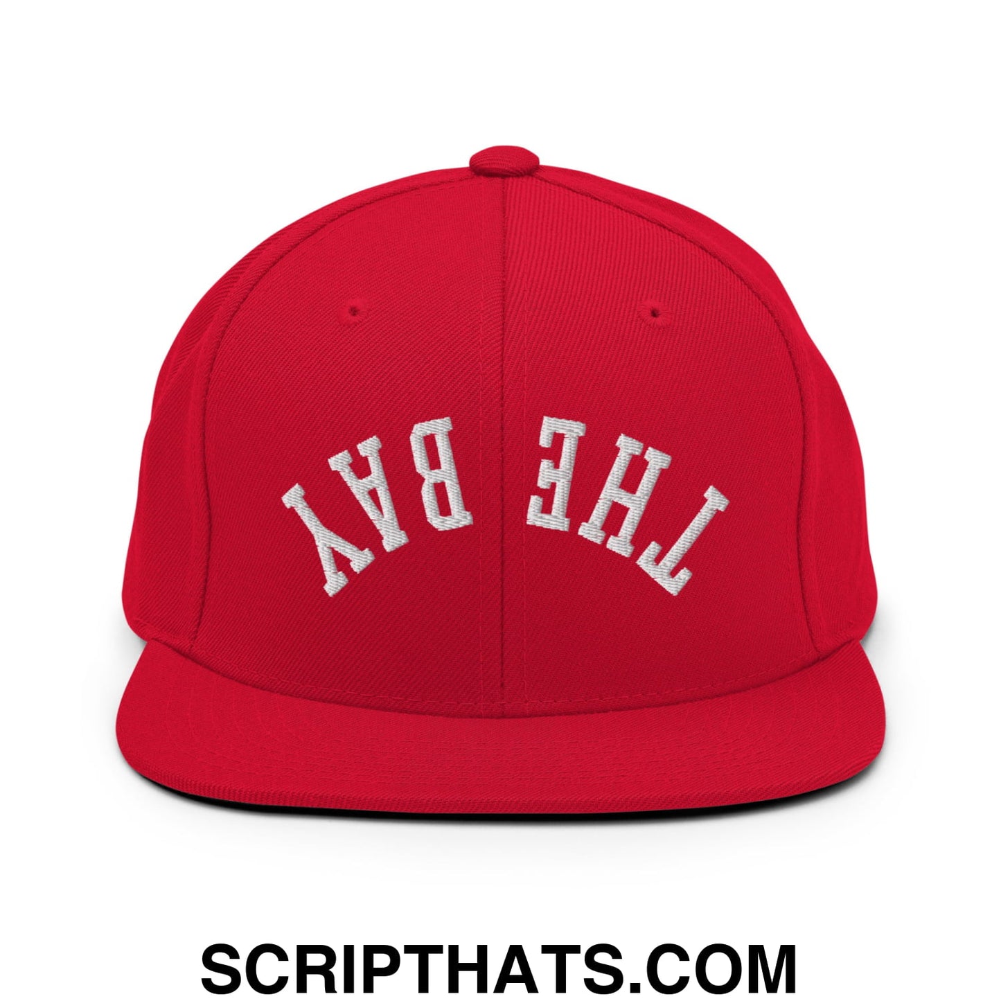Red snapback cap featuring white embroidered the bay lettering with a flat bill brim for casual streetwear use