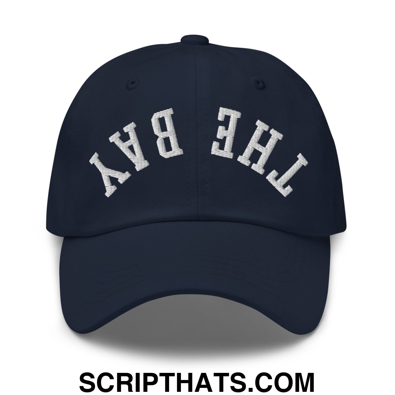 Navy blue unstructured dad hat with white arched embroidery reading the bay upside down on front panel