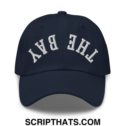 Navy blue unstructured dad hat with white arched embroidery reading the bay upside down on front panel