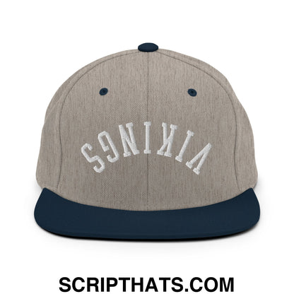 A heather gray snapback hat with a navy blue flat bill and white embroidered vikings lettering in an arched design